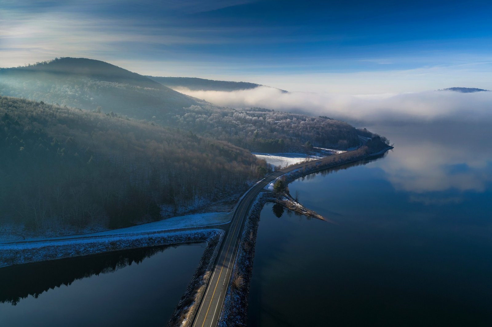 an aerial view of a road near a body of water